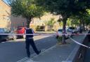 Police behind a cordon at the junction of Rushmore Road and Glyn Road