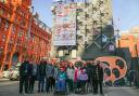 Students at New City College in front of their work at the 'digital canvas' near Old Street Roundabout in Shoreditch