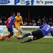 Alexander McQueen of Dagenham slots a rebound past O's keeper Dean Brill (Pic: Gavin Ellis/TGS Photo)