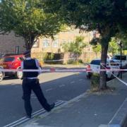 Police behind a cordon at the junction of Rushmore Road and Glyn Road