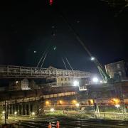 Pictured: Engineers putting in a temporary footbridge at Agar Grove in Camden