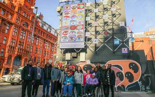 Students at New City College in front of their work at the 'digital canvas' near Old Street Roundabout in Shoreditch